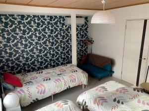 um quarto com 2 camas e uma parede azul e branca em B&B HOTTA em Sapporo