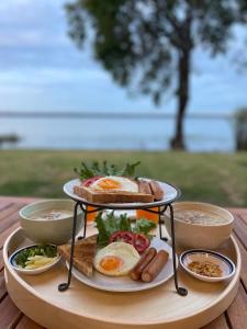 a tray of breakfast food on a wooden table at LAKE HOUSE Naka Cave in Ban Don Klang