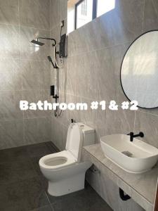 ein Badezimmer mit einem weißen WC und einem Waschbecken in der Unterkunft Allure Villa Cempaka Private Pool in Kuantan