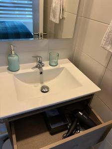 lavabo blanco en el baño con espejo en Depto nuevo en Santiago, en Santiago