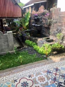 a garden with a water fountain in a yard at Raditya Homestay in Mambat