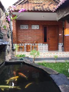 a koi pond in front of a house at Raditya Homestay in Mambat