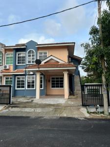 a blue and pink house with a gate at Banglo Semi D Villa D Doa Maju in Kuala Terengganu