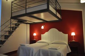 a bedroom with two beds and a spiral staircase at Agriturismo Roccadia in Carlentini