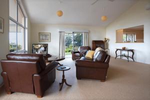 sala de estar con 2 sillas de cuero y sofá en Mhara Downs Country Escape, en Foster