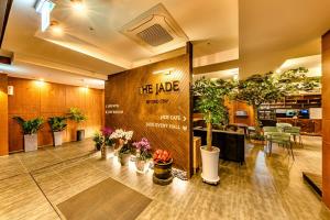 um lobby com vasos de plantas e um cartaz num edifício em The Jade Hotel em Jeju
