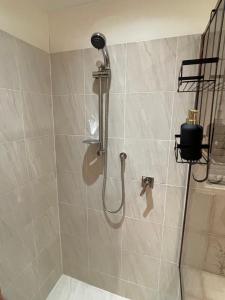 a shower with a shower head in a bathroom at Spacious 4BR getaway with panoramic water & mountain view in Green Point