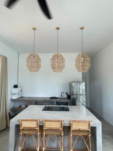 eine Küche mit einem Tisch mit 2 Stühlen und Hängelampen in der Unterkunft Allure Villa Cempaka Private Pool in Kuantan