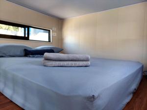 a bedroom with a large bed with two pillows on it at Tiny house with extended camping area for large groups in Puerto Viejo