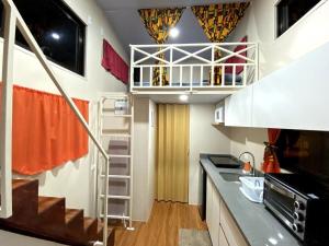 a small kitchen with a staircase in a room at Tiny house with extended camping area for large groups in Puerto Viejo