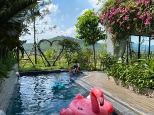 een kind dat speelt in een zwembad met roze opblaasbare dieren bij Villa 3 bedrooms Venus resort by Flamingo F12 or F24 in Thanh Cao