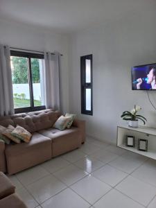 sala de estar con sofá y TV de pantalla plana en Casa com piscina no Campeche en Florianópolis