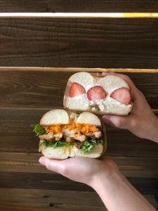 una persona sosteniendo un sándwich en su mano en B&B Sampark, en Shirahama