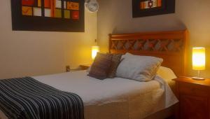 a bedroom with a bed with two lamps on both sides at Hostal del Aguila in Viña del Mar