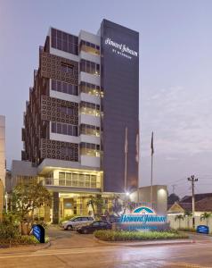 a large building with cars parked in a parking lot at Howard Johnson By Wyndham Pekalongan in Pekalongan