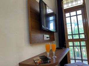 瑞詩凱詩的住宿－Hotel Krishna Rishikesh，木桌旁的两杯橙汁