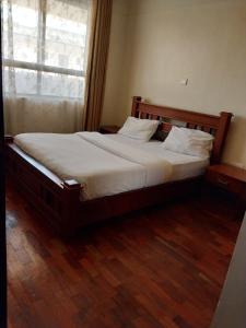 a large bed in a room with a window at Sky view three bedroom in Nairobi