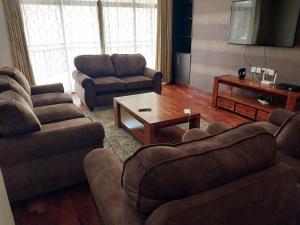 ein Wohnzimmer mit 2 Sofas und einem Couchtisch in der Unterkunft Sky view three bedroom in Nairobi