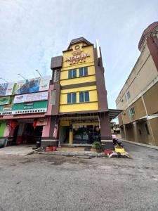 un edificio giallo con un cartello sopra di Intanova Hotel a Teluk Intan