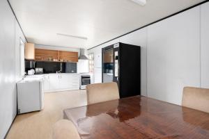 a kitchen with a table and a black refrigerator at Collins Street Guest House in Kalgoorlie