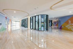 Brand New Studio Near Dubai Airport في دبي: لوبي كبير مع مدخل كبير مع نوافذ زجاجية