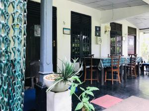 a dining room with a table and a potted plant at Asiri HomeStay in Sigiriya