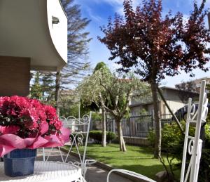 una mesa con un jarrón de flores rosas. en Residenza Nobel Appartamenti, en Rímini