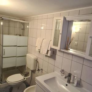 uma casa de banho branca com um WC e um lavatório em Apartments Berto - 500m from beach em Rovinj