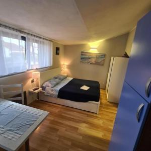 um quarto com uma cama, uma mesa e um frigorífico em Apartments Berto - 500m from beach em Rovinj
