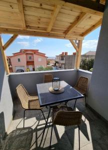 patio con mesa y sillas en el balcón en Apartments Ned, en Mandre
