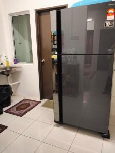 a glass refrigerator in a room with a door at Camelia Homestay in Seri Iskandar