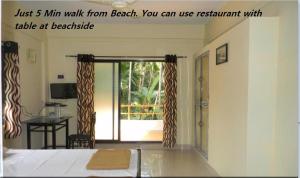een kamer met een bed en een deur met een balkon bij Suma beach resort in Dapoli