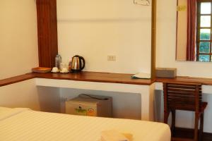 a bedroom with a desk with a bed and a chair at Annowa Resort - Chanthaburi in Chanthaburi