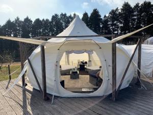ein weißes Zelt mit einem Wohnzimmer in der Unterkunft くじゅう花公園　キャンピングリゾート花と星 in Kuju