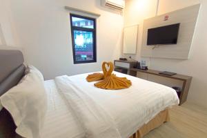 Una habitación de hotel con una cama con una toalla. en BATAM 1 HOTEL en Nagoya