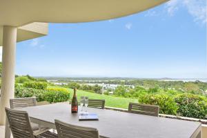 a bottle of wine sitting on a table on a balcony at Crest Premium View Apartment 19 in Noosa Heads