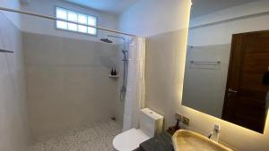 ein Badezimmer mit einem Waschbecken, einem WC und einem Spiegel in der Unterkunft Khamara Nusa Penida in Nusa Penida
