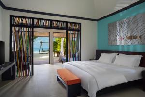 a bedroom with a large bed and a swing at Dhawa Ihuru - All Inclusive in Male City