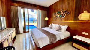 a bedroom with a bed and a view of the ocean at Khamara Nusa Penida in Nusa Penida