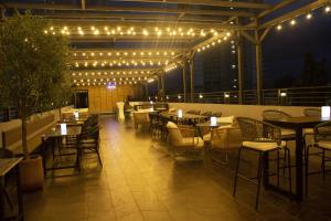 a rooftop patio with tables and chairs and lights at BATAM 1 HOTEL in Nagoya