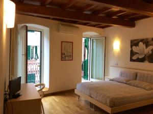 a bedroom with a bed and a desk and windows at La Dolce Vita in Riomaggiore