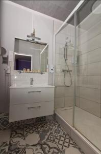 y baño con ducha, lavabo y espejo. en Logis Hôtel Le Bocage, en Montmarault