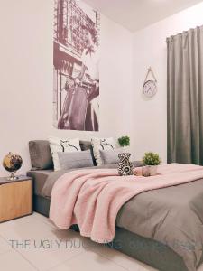um quarto com uma cama grande e um cobertor rosa em THE UGLY DUCKLING HOMESTAY em Kampung Dengkil