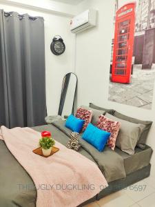 um sofá cinzento com almofadas e uma cabina telefónica vermelha em THE UGLY DUCKLING HOMESTAY em Kampung Dengkil