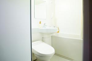 bagno bianco con servizi igienici e lavandino di Hotel Meldia Kyotoshijoomiya a Kyoto