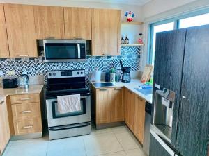 a kitchen with a stove and a microwave at Amazing Ocean View Luxury Condo in Coronado Panama in Playa Coronado