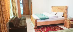een slaapkamer met een bed, een stoel en een raam bij Al-Sadiq Hotel & Restaurant Malam Jabba Swat in Swat