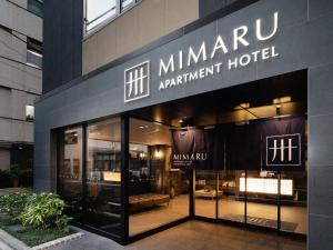 東京的住宿－MIMARU TOKYO GINZA EAST，大楼一侧的mhmarma公寓标志
