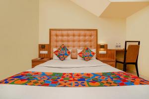 a bedroom with a large bed with a colorful blanket at FabExpress Emerald Inn in Mumbai