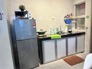 een keuken met een koelkast en een wastafel bij Feel Homestay in Cameron Highlands